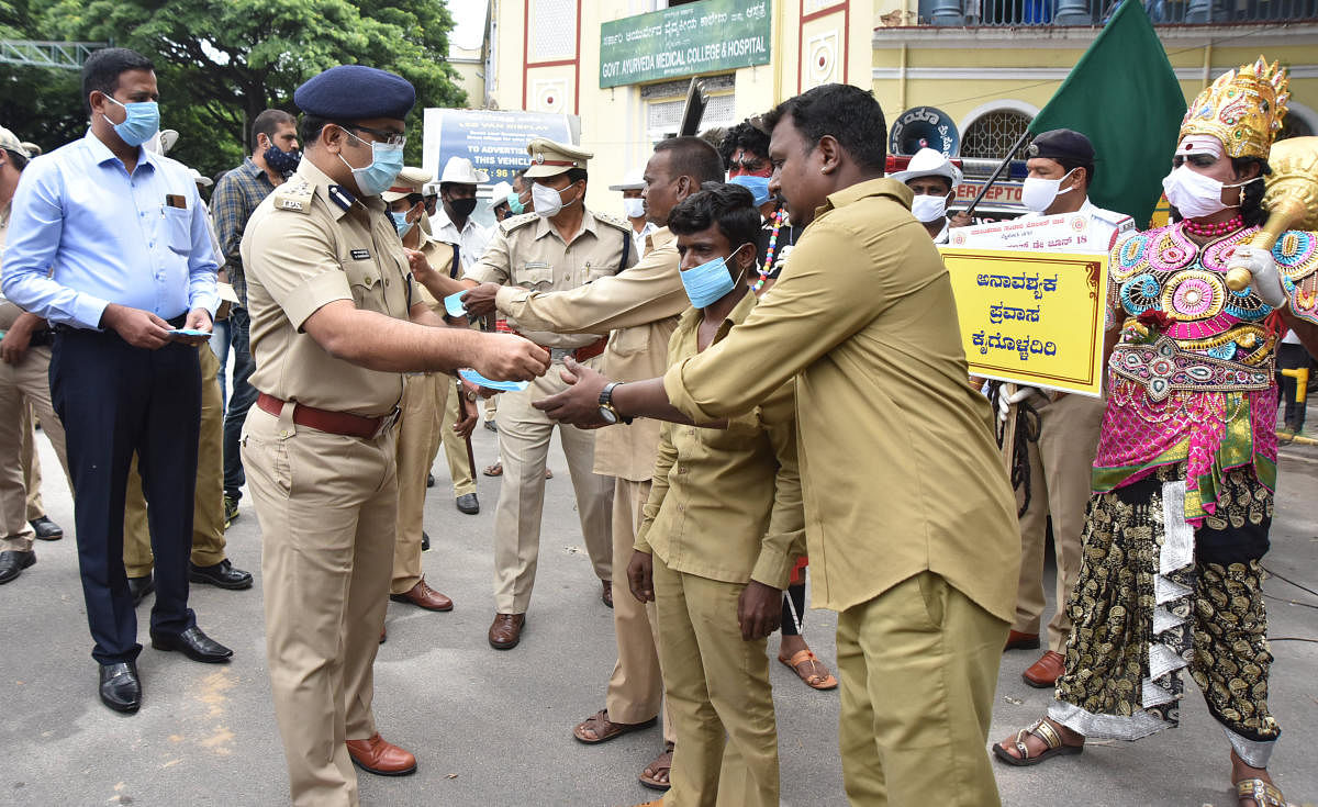 City Police Commissioner Chandragupta distributes masks to the people on the occasion of Mask Day at Ayurveda College Circle in Mysuru on Thursday. DH PHOTO