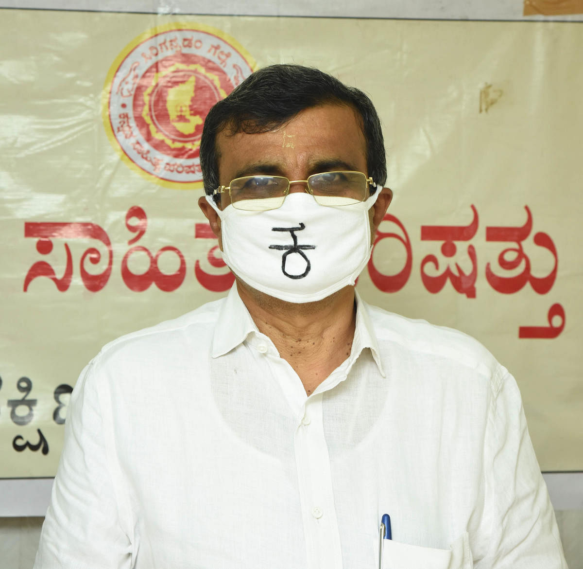 Pradeep Kumar Kalkura wears a mask with Kannada alphabet 'Ka.'