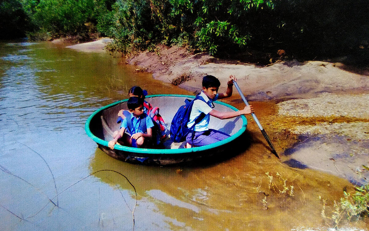 A file picture of Abhishekh and his cousins using the ‘Theppa' (Coracle) to cross River Bhadra to attend school in Magundi in Mudigere taluk.