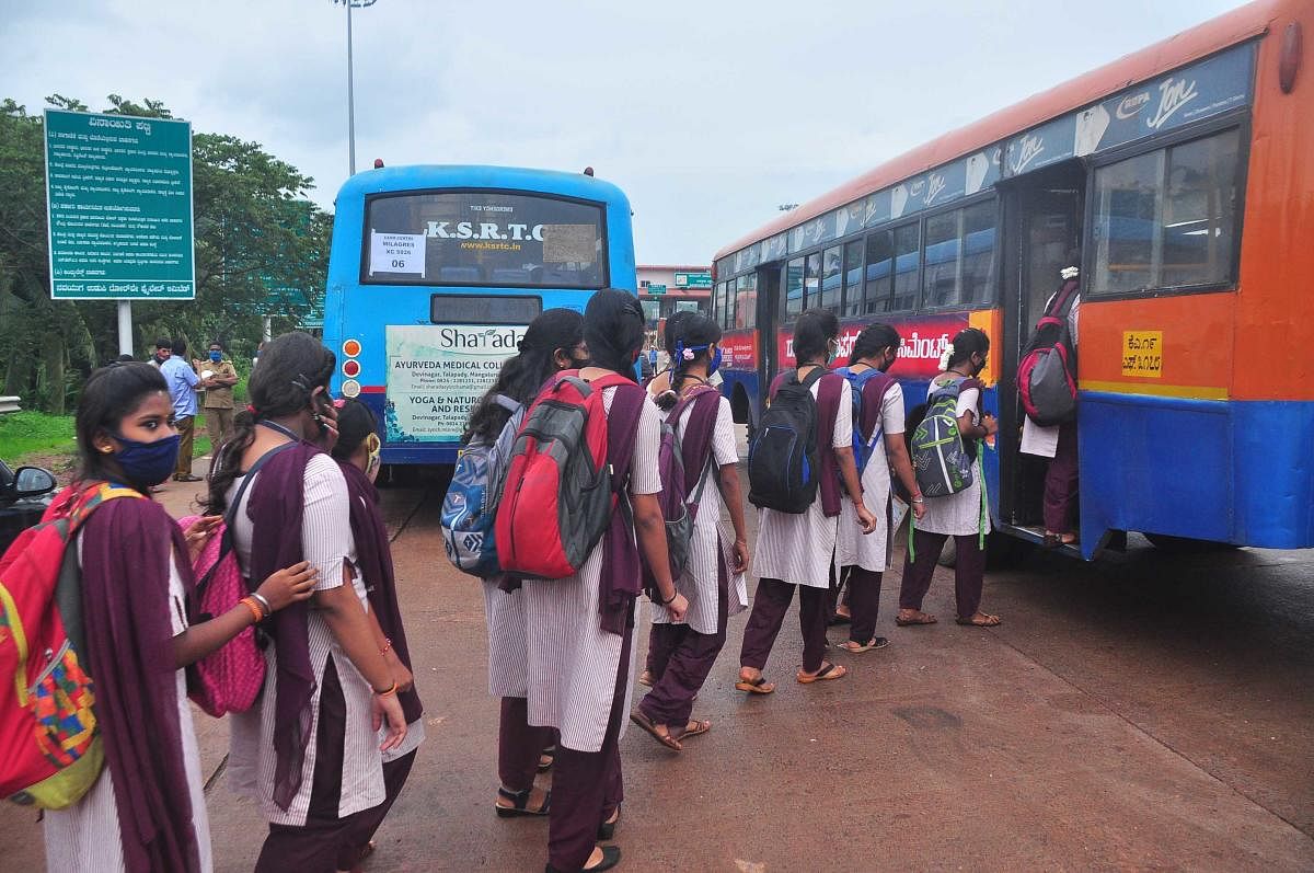 Students board buses ferrying them to their examination centres near Talapady check post on Thursday.