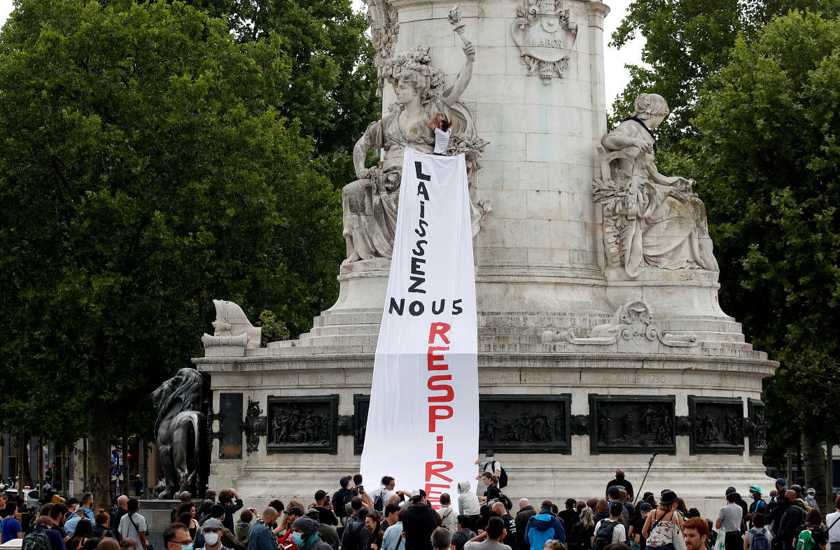 Demonstrators hang a banner as they attend a demonstration to protest against police brutality, racial inequality and the death in Minneapolis police custody of George Floyd in Paris, France, June 20, 2020. Credit: Reuters
