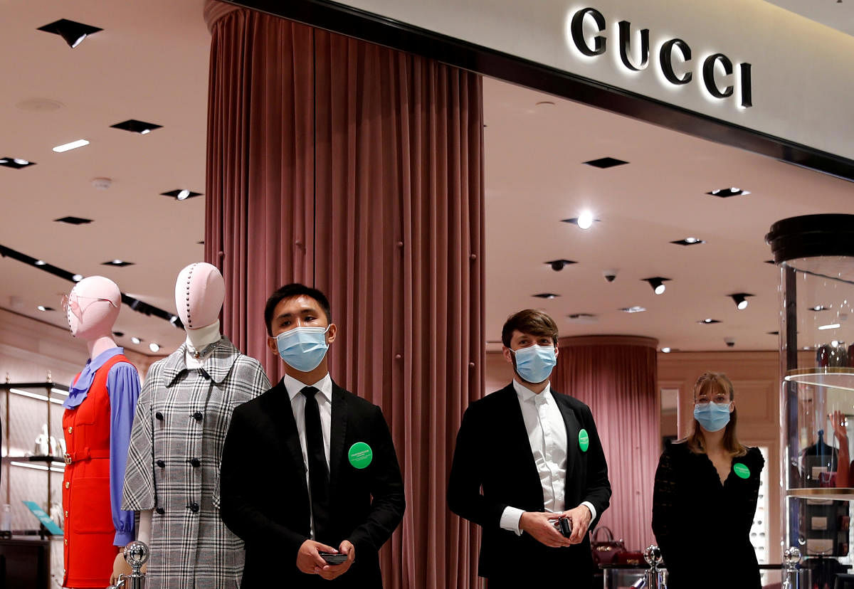  Staff members, wearing protective face masks, stand in front of a Gucci shop inside the department store Le Printemps Haussmann before its reopening in Paris as France eases gradually its lockdown measures and restrictions following the outbreak of the coronavirus disease (COVID-19) in France, May 28, 2020. Credit/Reuters File Photo