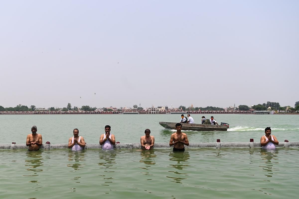 Hindu devotees take a holy dip and offer prayers in the waters of the Brahma Sarovar, a sacred pond, during a solar eclipse in Kurukshetra (AFP Photo)