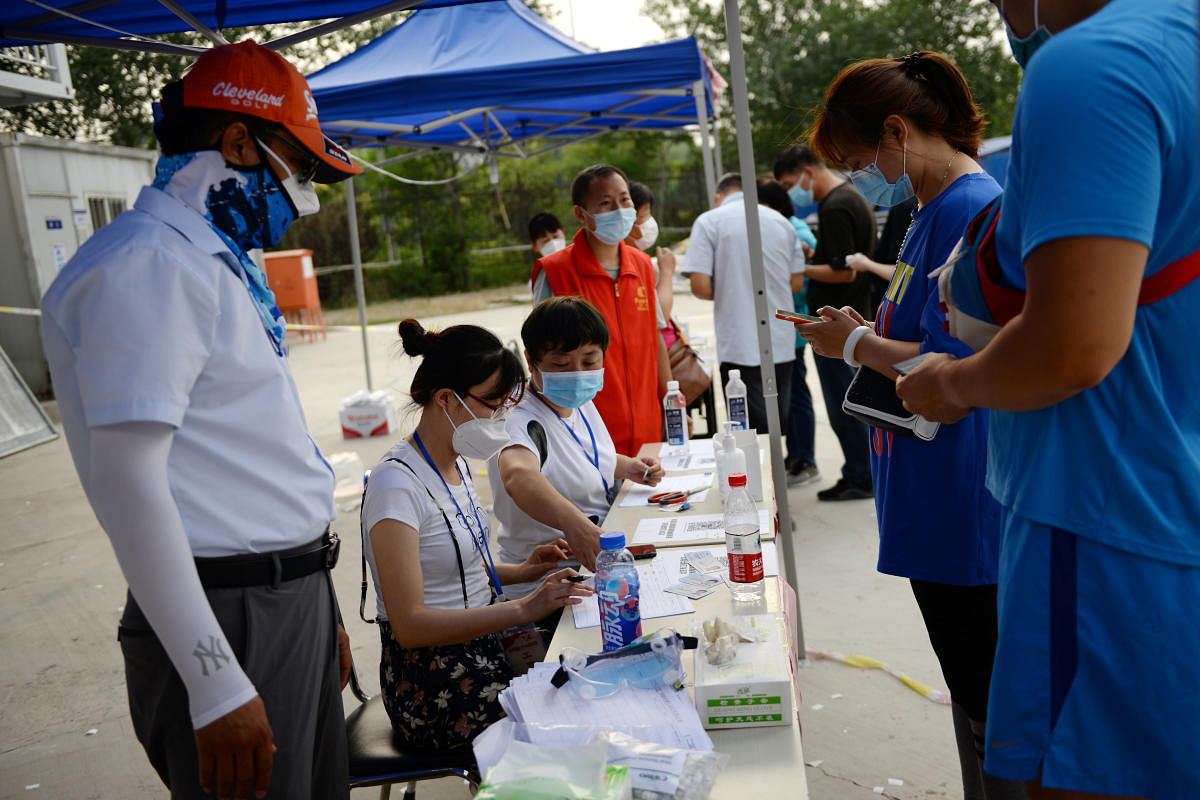 People register personal information before they receive nucleic acid tests, following a new outbreak of the coronavirus disease in China (Reuters Photo)
