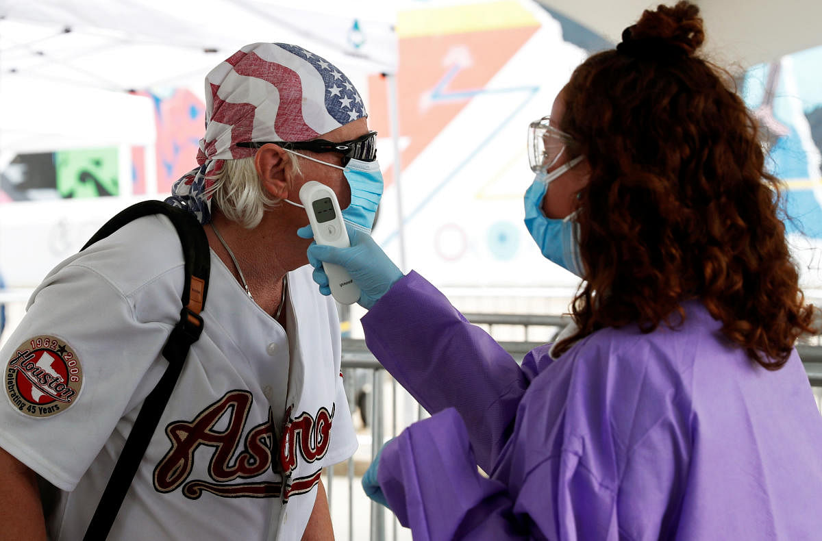 A supporter wearing a face mask has his temperature checked outside the venue for US President Donald Trump's rally in Tulsa. Reuters
