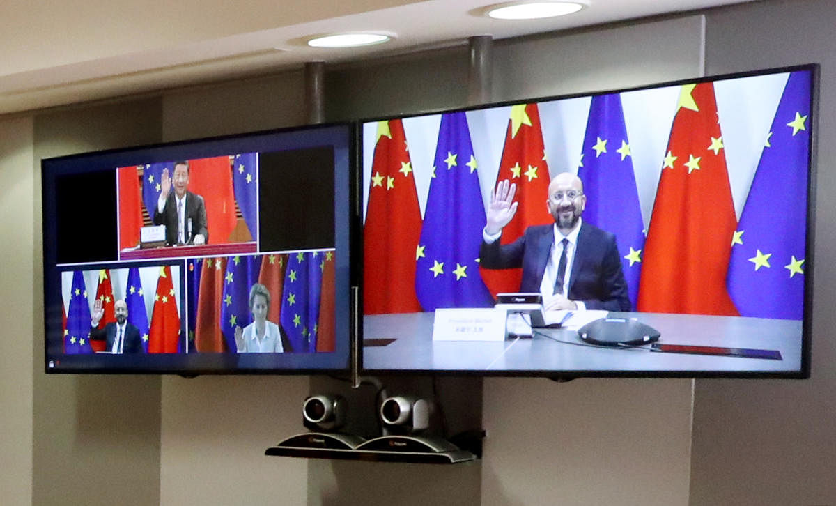 European Council President Charles Michel (R) is seen on a screen as he attends a virtual summit with European Commission President Ursula von der Leyen and Chinese President Xi Jinping (AFP Photo)