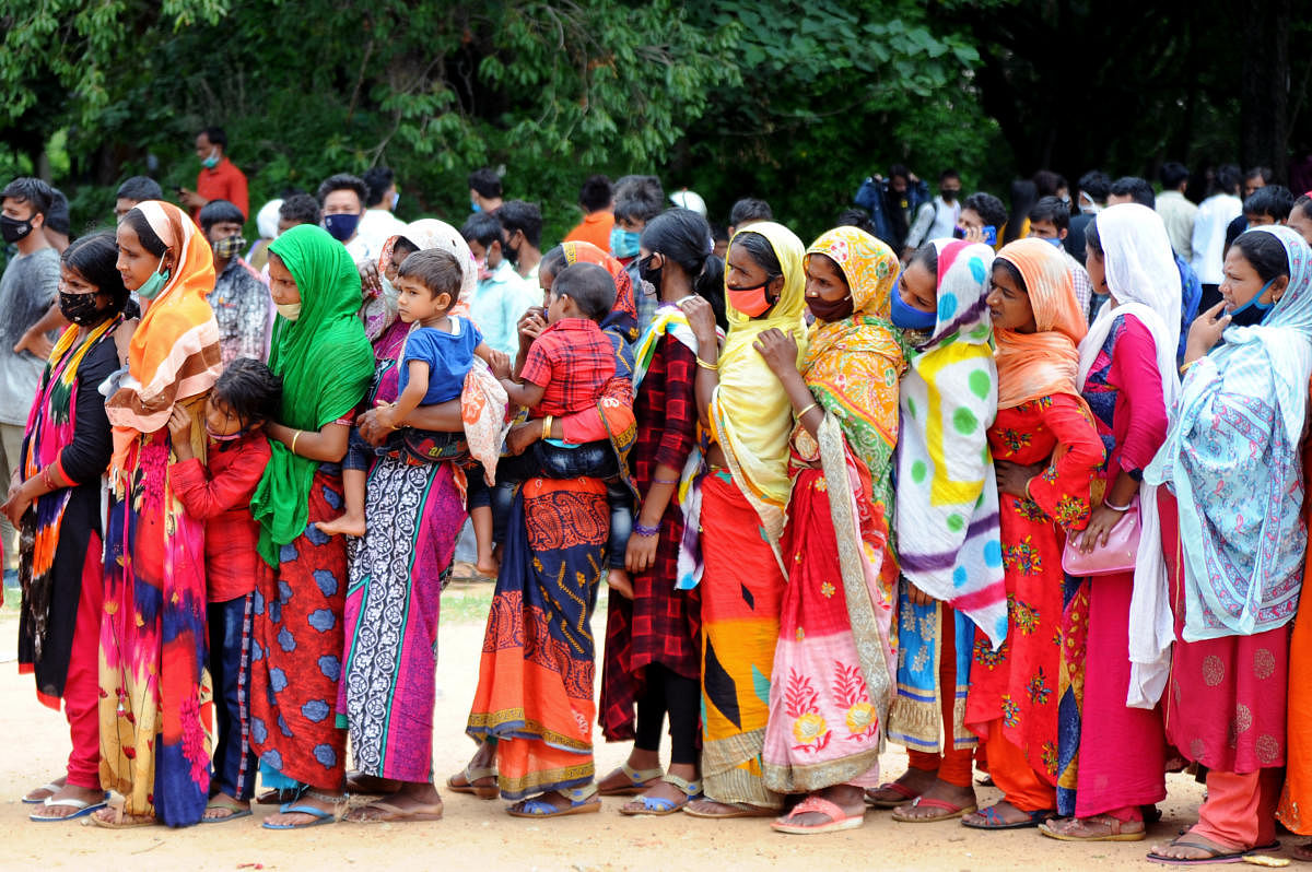 Women migrant workers stand in a queue for food and water at Palace Grounds in Bengaluru. DH File Photo