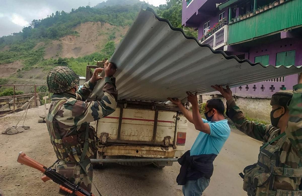 Assam Rifles personnel unload tin-sheets from a van for construction of quarantine facility at Kisama heritage village in Kohima. PTI
