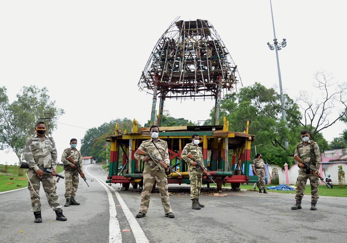 Police personnel stand guard in front of a chariot of Lord Jagannath during the Rath Yatra festival, amid the ongoing coronavirus pandemic, in Ranchi. Credit: PTI