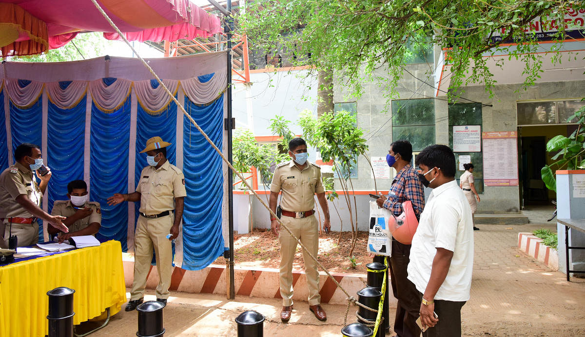 The staff of the Peenya police station work in a kiosk set up outside the station on Monday. DH photo/B H SHIVAKUMAR