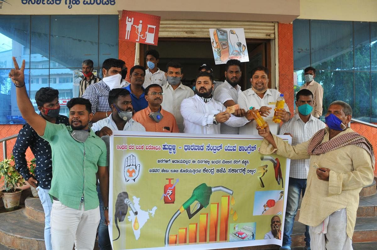 Indian Youth Congress symbolically sell petrol, during their protest against petrol-diesel price hike, in front of Mini Vidhan Soudha in Hubballi on Tuesday. (DH Photo)