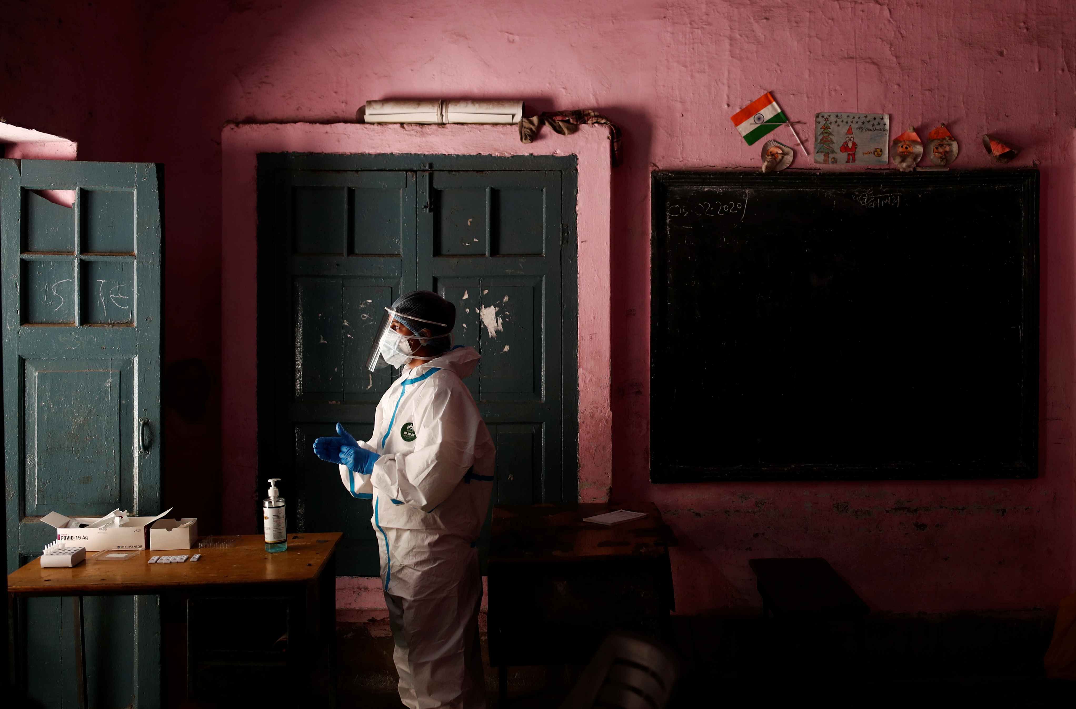 A medical worker wearing a Personal Protective Equipment (PPE) suit waits for the next person to get tested at a school turned into a centre to conduct tests for the coronavirus disease (COVID-19), amidst its spread in New Delhi. Credit: Reuters