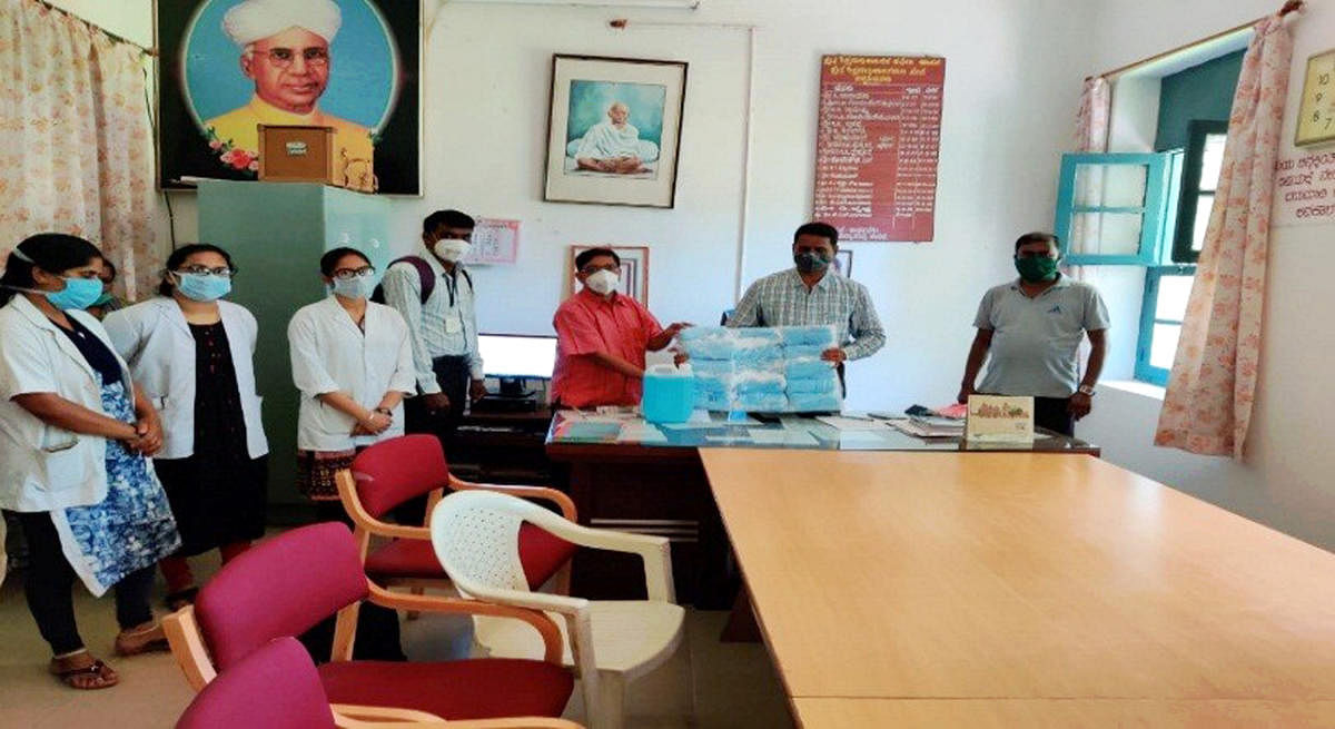 Volunteers of Swami Vivekananda Youth Movement donate 5,000 masks and 100 litres of sanitiser to Hassan taluk Block Education Officer Balaram in Hassan recently.  DH PHOTO