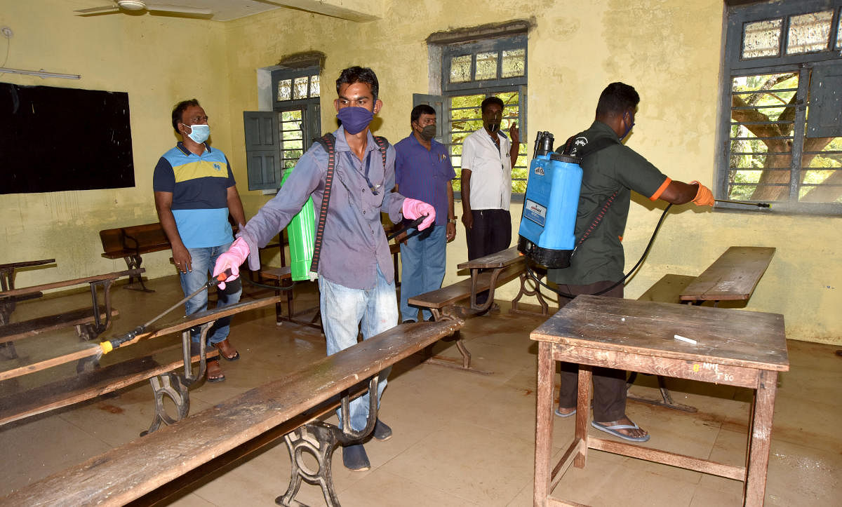Ahead of SSLC examination, workers spray disinfectant to an examination hall at Maharaja PU College in Mysuru on Wednesday. 