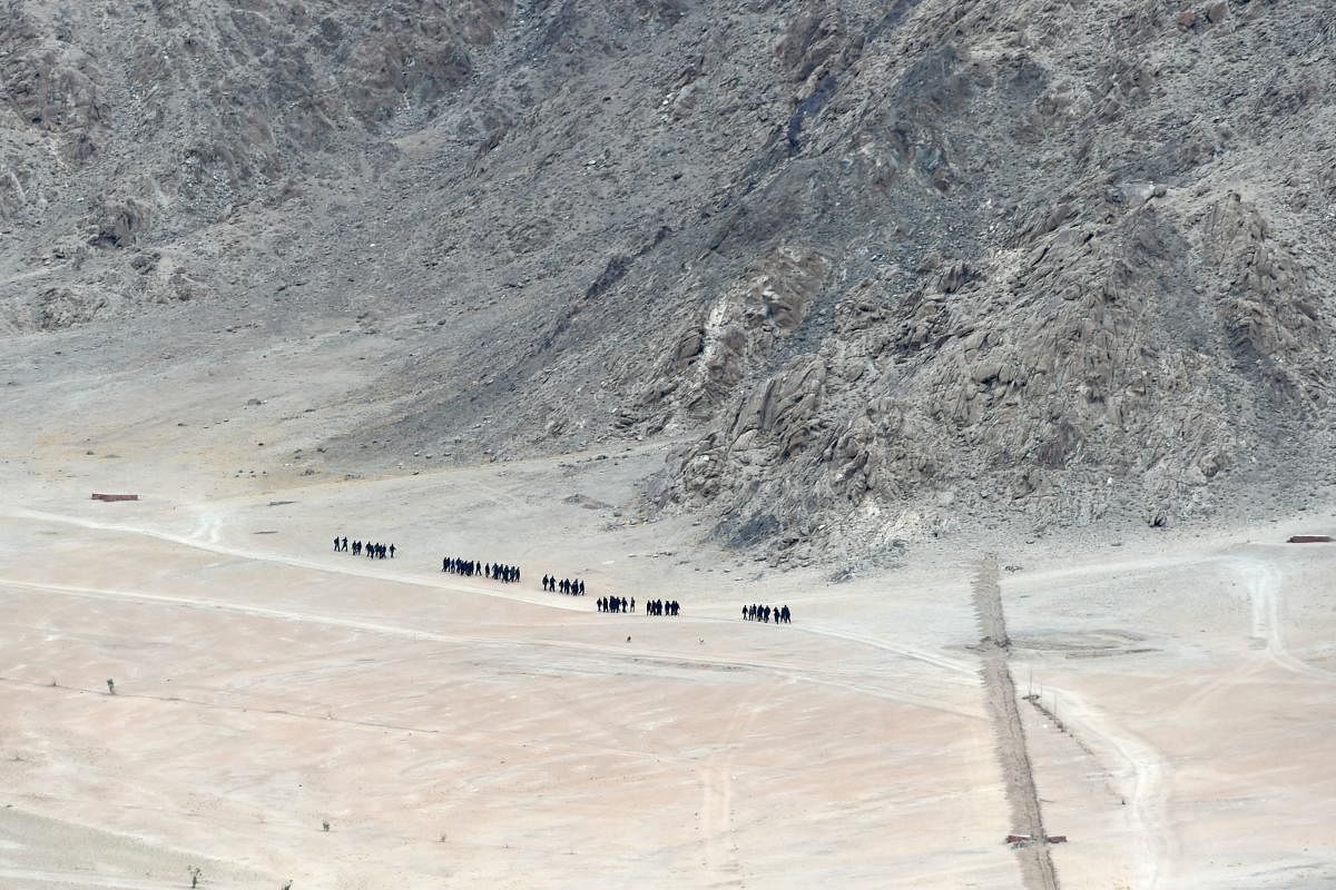 Indian soldiers walk at the foothills of a mountain range near Leh, the joint capital of the union territory of Ladakh, on June 24, 2020. (AFP)