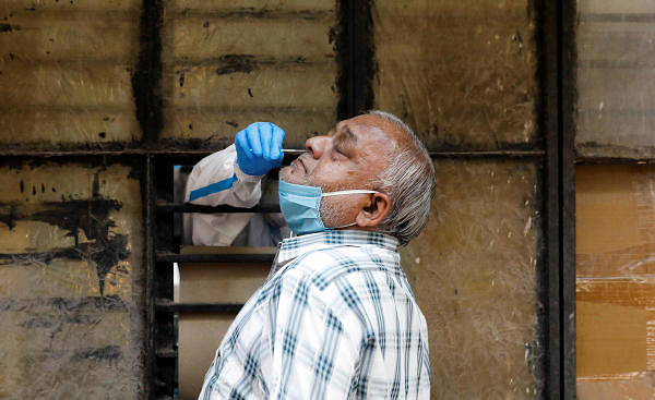 A medical worker collects a sample from a man at a school turned into a centre to conduct tests for the coronavirus disease (COVID-19), amidst its spread in New Delhi, India June 22, 2020. Credit: Reuters