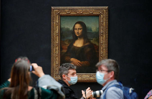 Media people, wearing protective face masks, stand in front of the painting "Mona Lisa" (La Joconde) by Leonardo Da Vinci at the Louvre museum in Paris as the museum prepares to reopen its doors to the public following the coronavirus disease (COVID-19) outbreak in France, June 23, 2020. Credit: Reuters