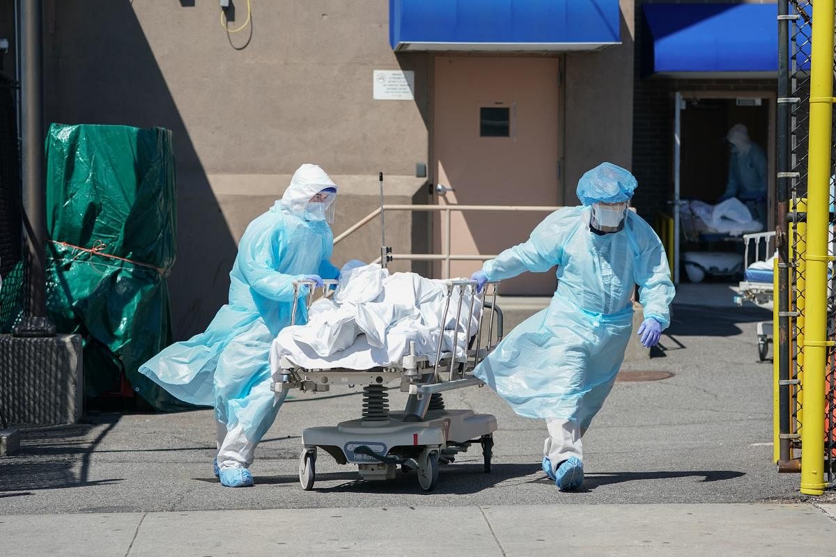  In this file photo taken on April 06, 2020 bodies are moved to a refrigeration truck serving as a temporary morgue at Wyckoff Hospital in the Borough of Brooklyn in New York. Credid/AFP Photo