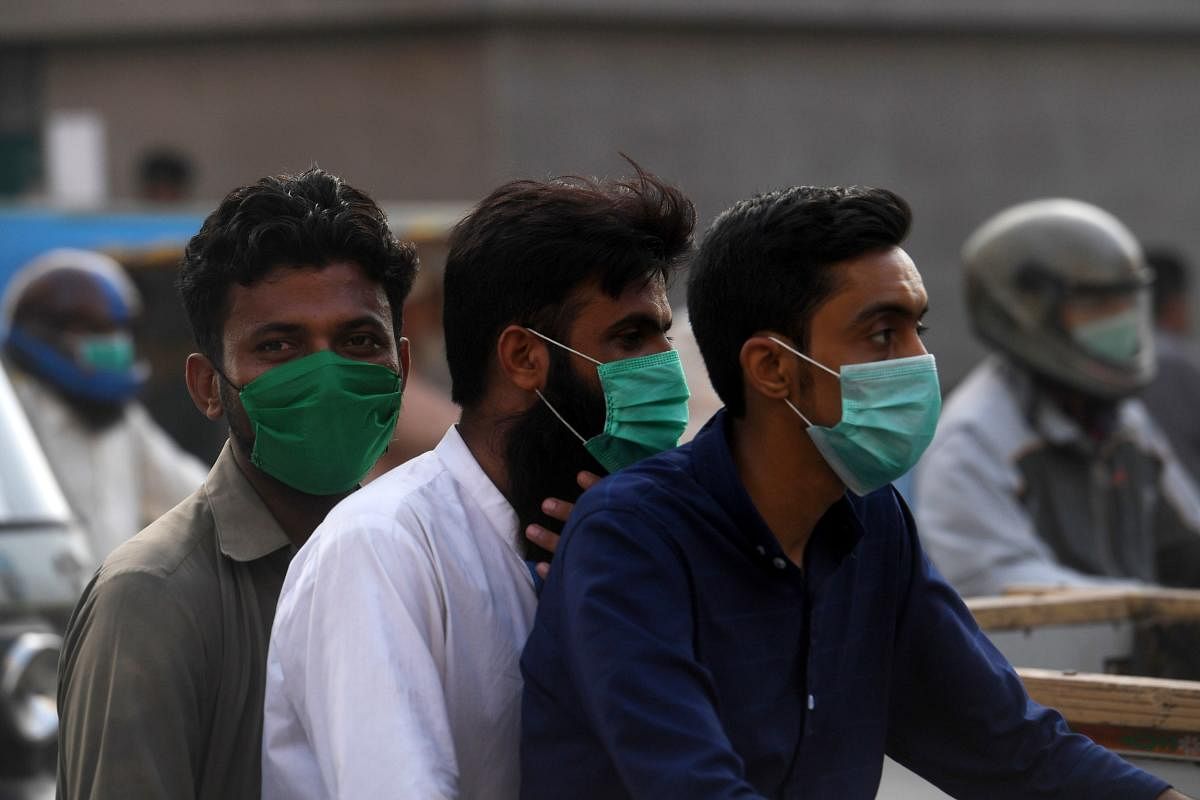 Commuters wearing facemasks ride on a bike on a street in Karachi on June 22, 2020 as the COVID-19 coronavirus cases continue to rise. Credit/AFP Photo