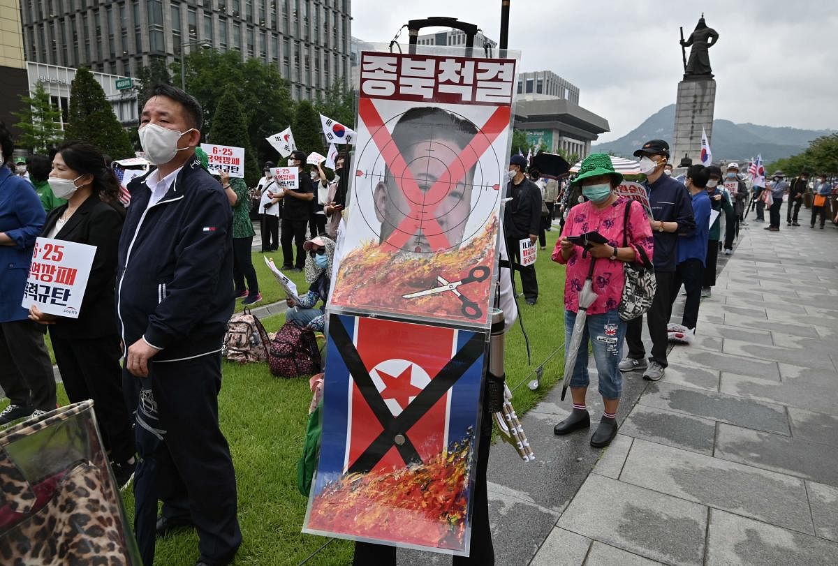 A South Korean man holds a placard showing a defaced portrait of North Korean leader Kim Jong Un during a rally commemorating the 70th anniversary of the beginning of the Korean War in Seoul on June 25, 2020. Credit/AFP Photo