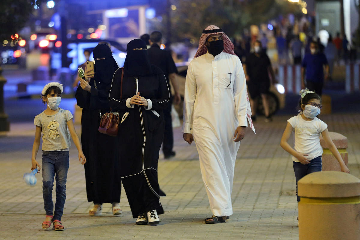 A Saudi family wearing protective face masks walk on Tahlia Street as nightlife kicks off, after the government loosened lockdown restrictions following the outbreak of the coronavirus disease (COVID-19), in Riyadh, Saudi Arabia June 21, 2020. Credit/Reuters File Photo