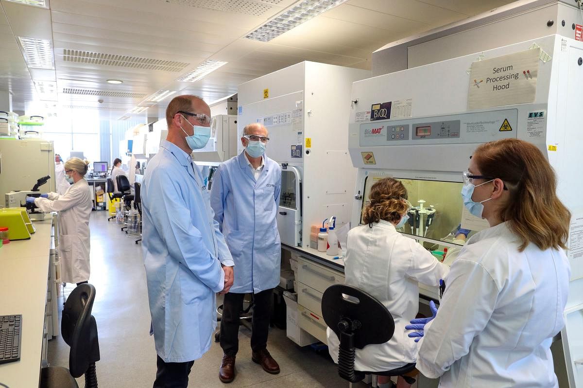 Britain's Prince William, Duke of Cambridge (2L), wearing PPE (personal protective equipment), of a face mask or covering, eye protection and an overall as a precautionary measure against spreading COVID-19, meets scientists including Christina Dold (R) during a visit to the manufacturing laboratory where a vaccine against the novel coronavirus COVID-19 has been produced at the Oxford Vaccine Group's facility at the Churchill Hospital in Oxford, west of London on June 24, 2020. Credit/AFP Photo