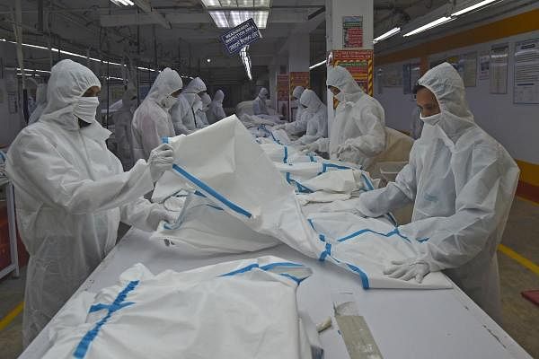In this picture taken on June 18, 2020, labourers from Beximco Textiles Ltd manufacturer work on Personal Protective Equipment (PPE) garment used as a preventive measure against the COVID-19 coronavirus, in Savar on the outskirts of Dhaka. Credit: AFP photo