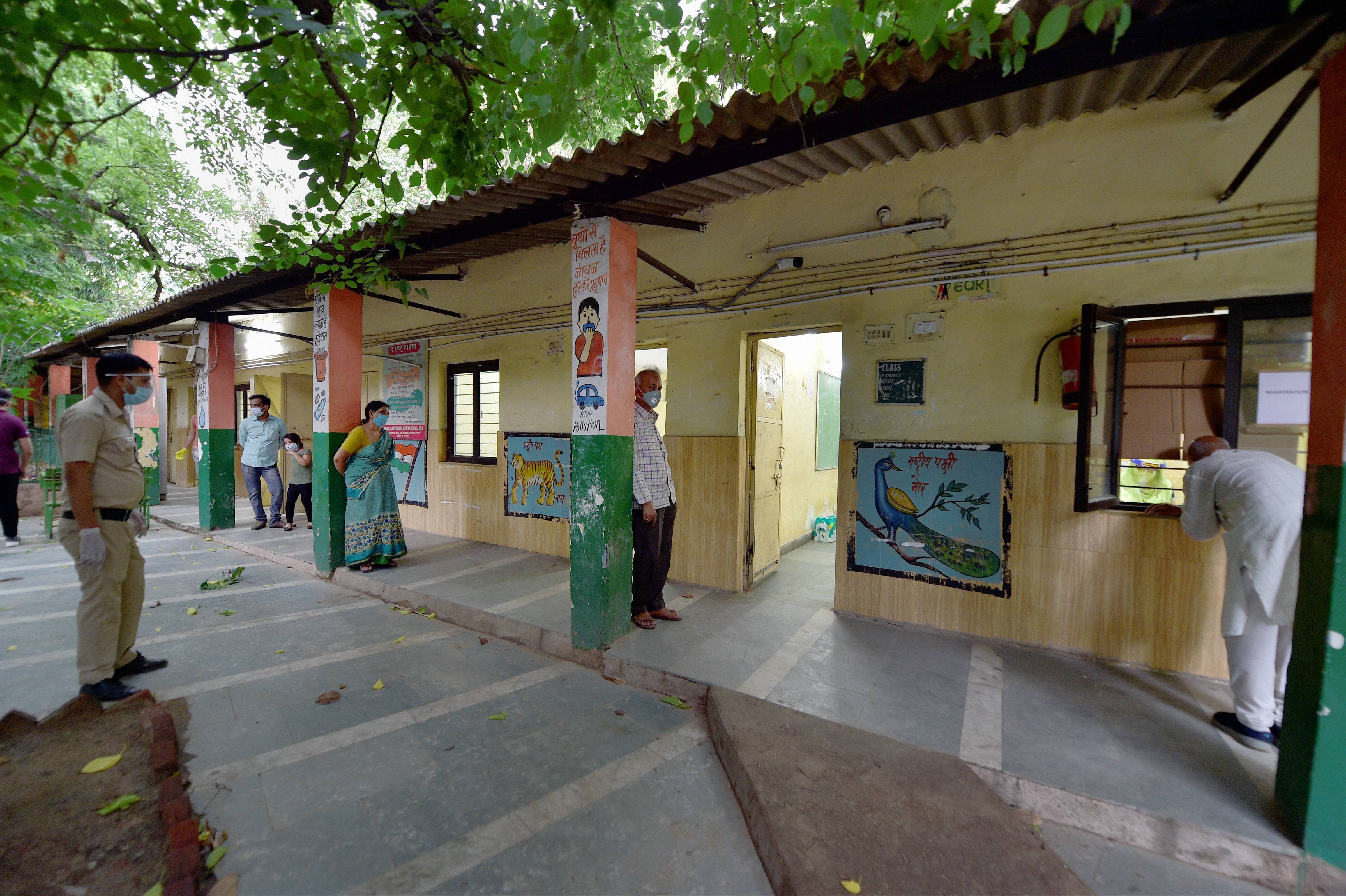 People wait in a queue maintaining physical distance to give samples for COVID 19 tests, at a school at Aruna Asaf Ali Road in New Delhi, Thursday, June 25, 2020. (PTI Photo)
