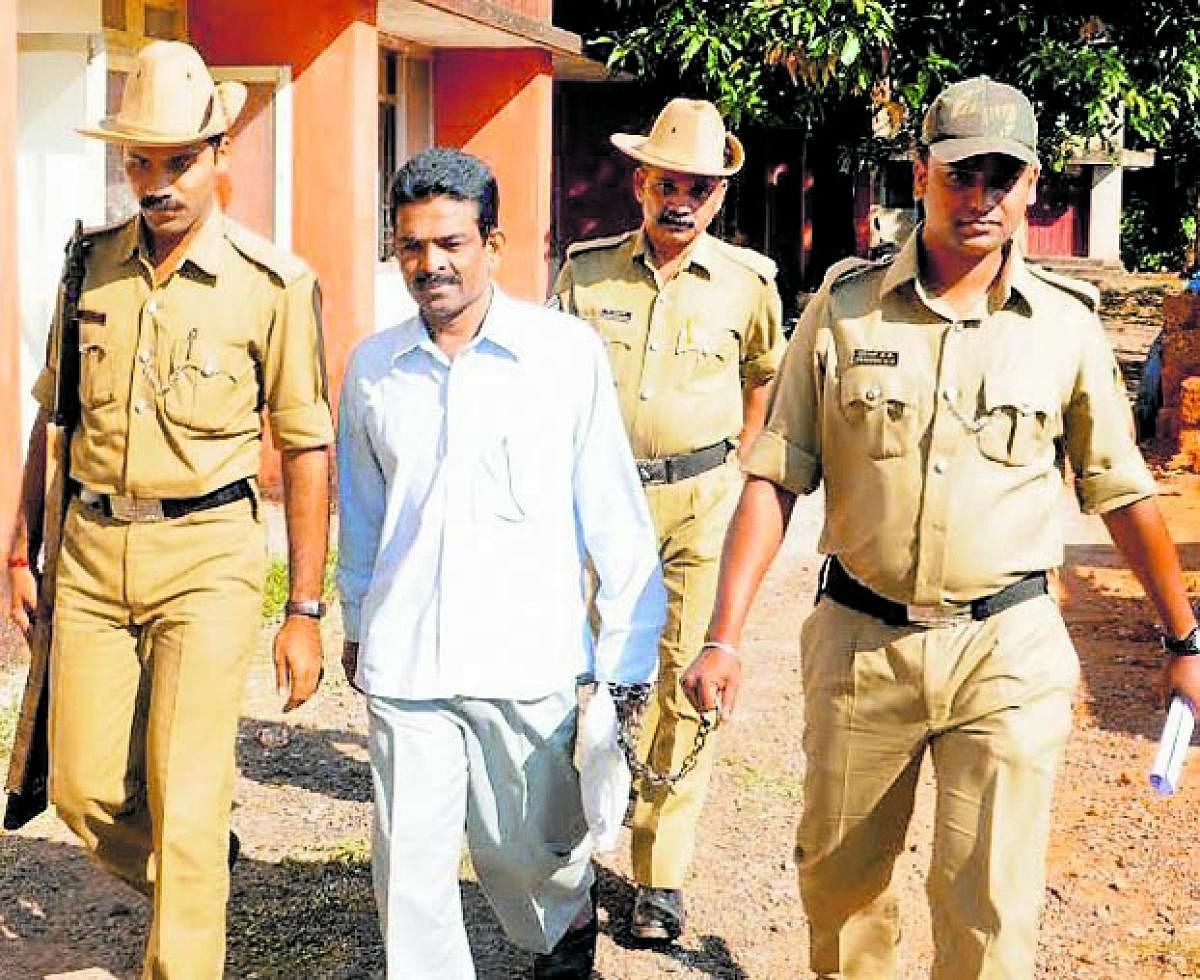 File picture of Cyanide Mohan being escorted out of the court by police.