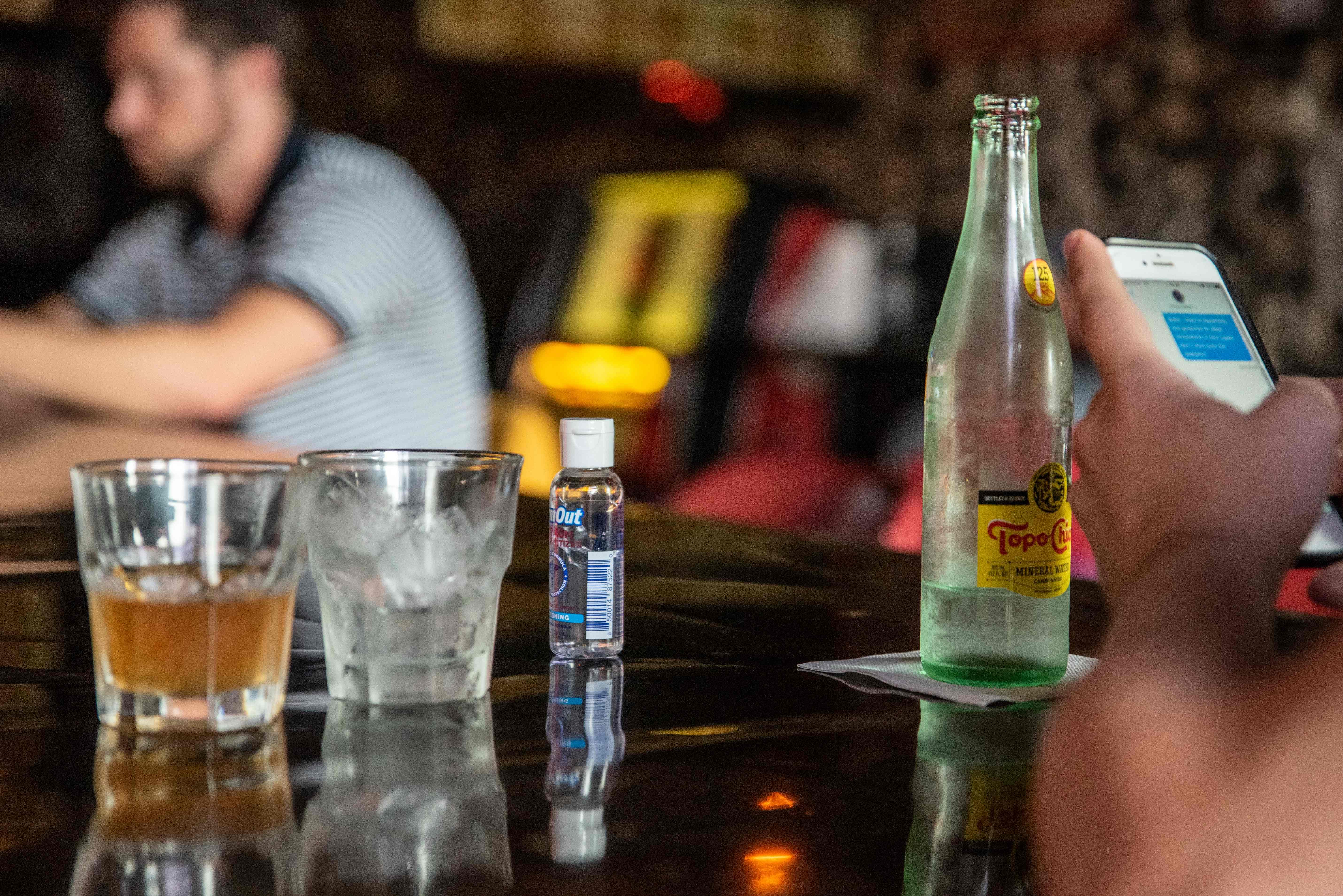 A bottle of hand sanitizer sits on a bar next to drinks at a restaurant in Austin, Texas, June 26, 2020. Credit: AFP Photo