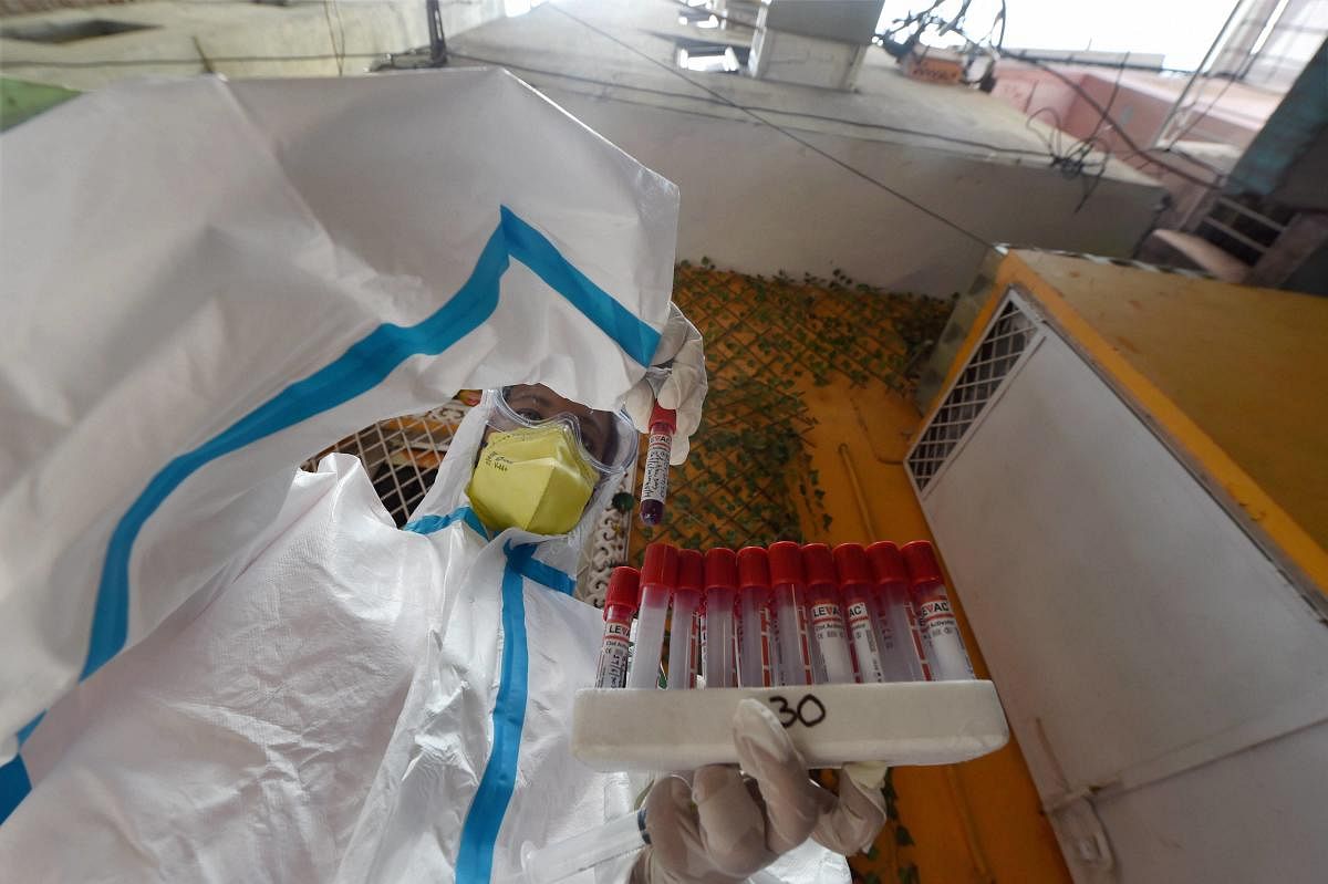 A medic collects samples during door-to-door COVID-19 testing, at Paharganj in New Delhi, Saturday, June 27, 2020. Credit/PTI Photo