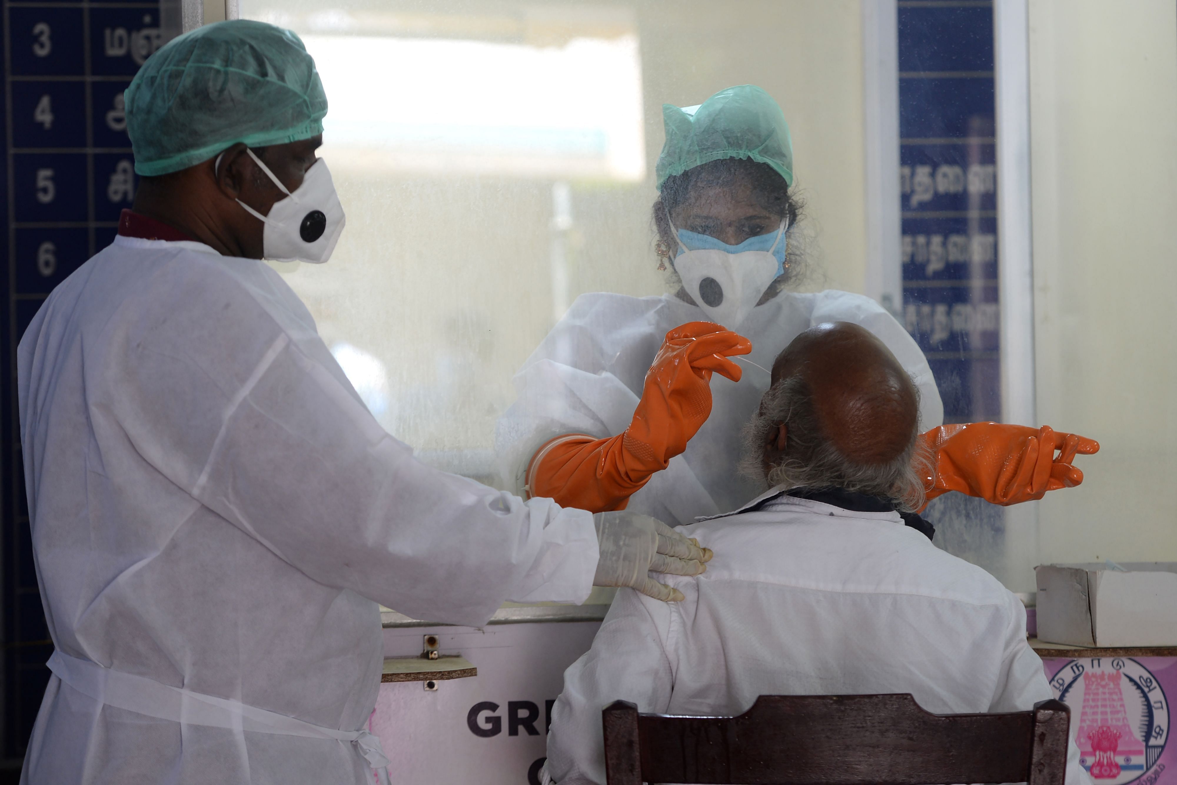 Medical technicians collect a sample from a elderly man at a Covid-19 testing centre in Chennai. Credit: AFP