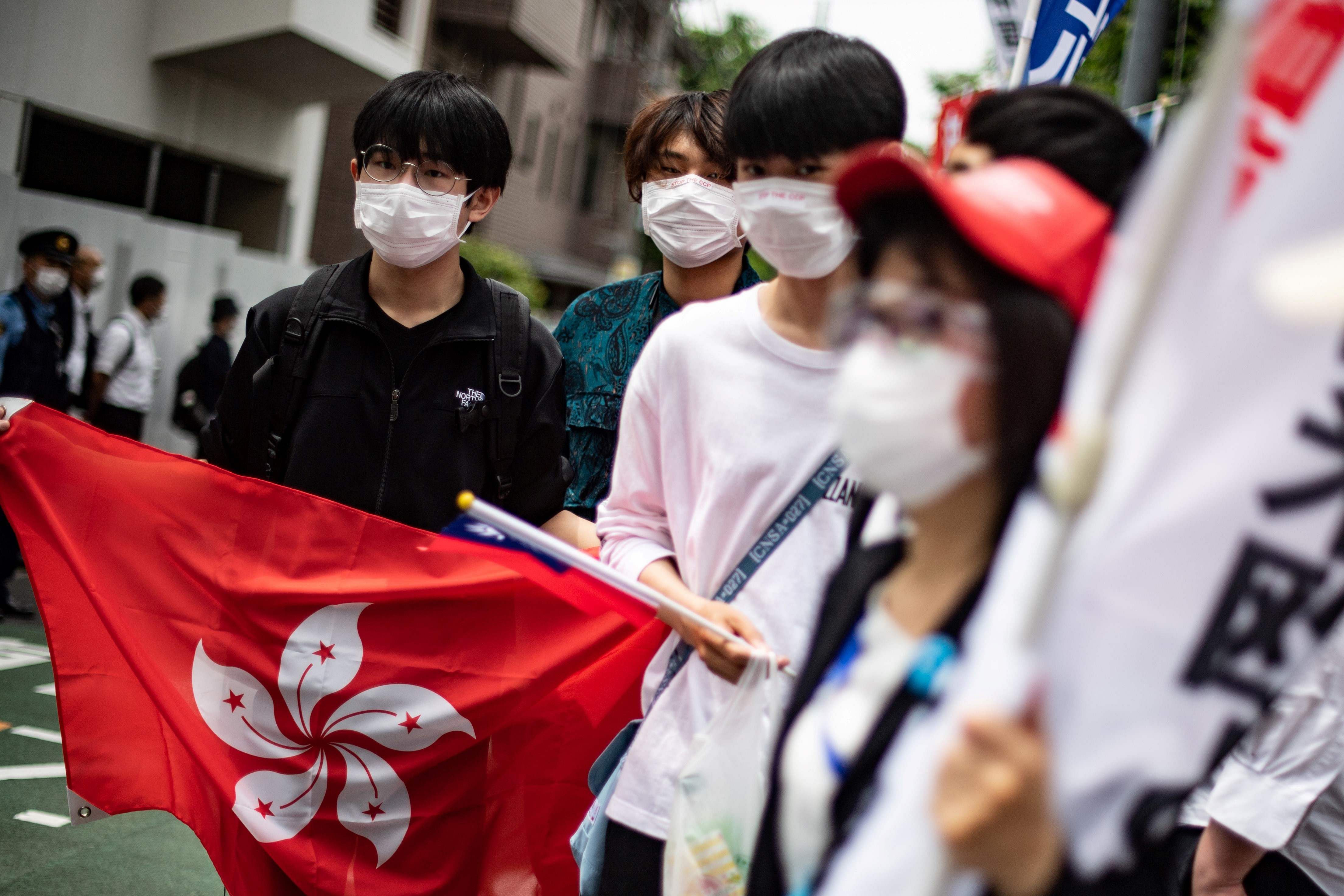 A group of pro-democracy activists hold a Hong Kong flag as they march to the Chinese embassy to mark the 31st anniversary of the June 4, 1989 crackdown on Beijing pro-democracy protest, in Tokyo on June 4, 2020. (Photo by AFP)