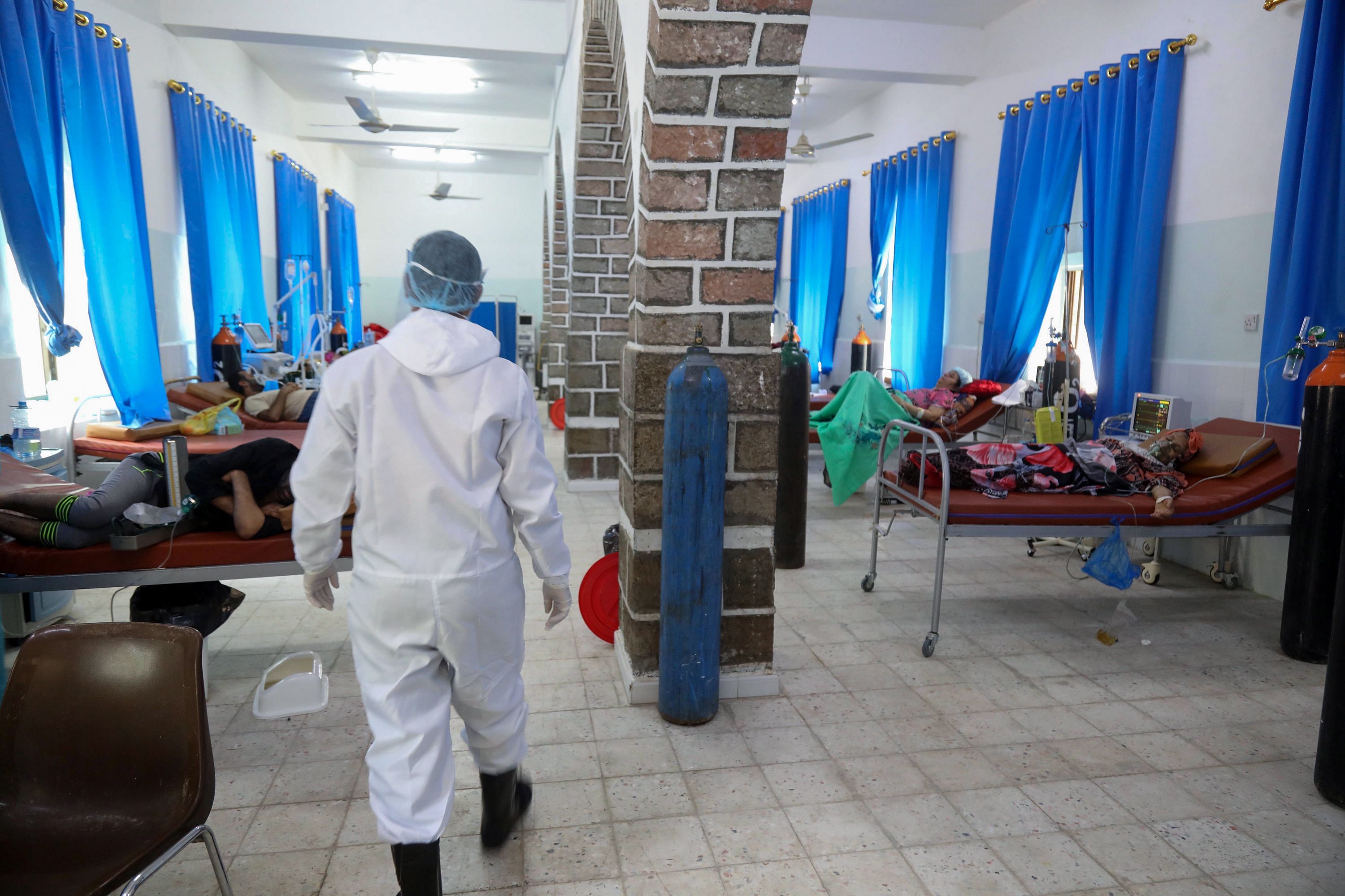 A Yemeni member of the medical staff in a full hazmat suit walks in the patient ward at a quarantine center where COVID-19 patients are treated in Yemen's third city of Taez, on June 21, 2020. (Photo by AFP)