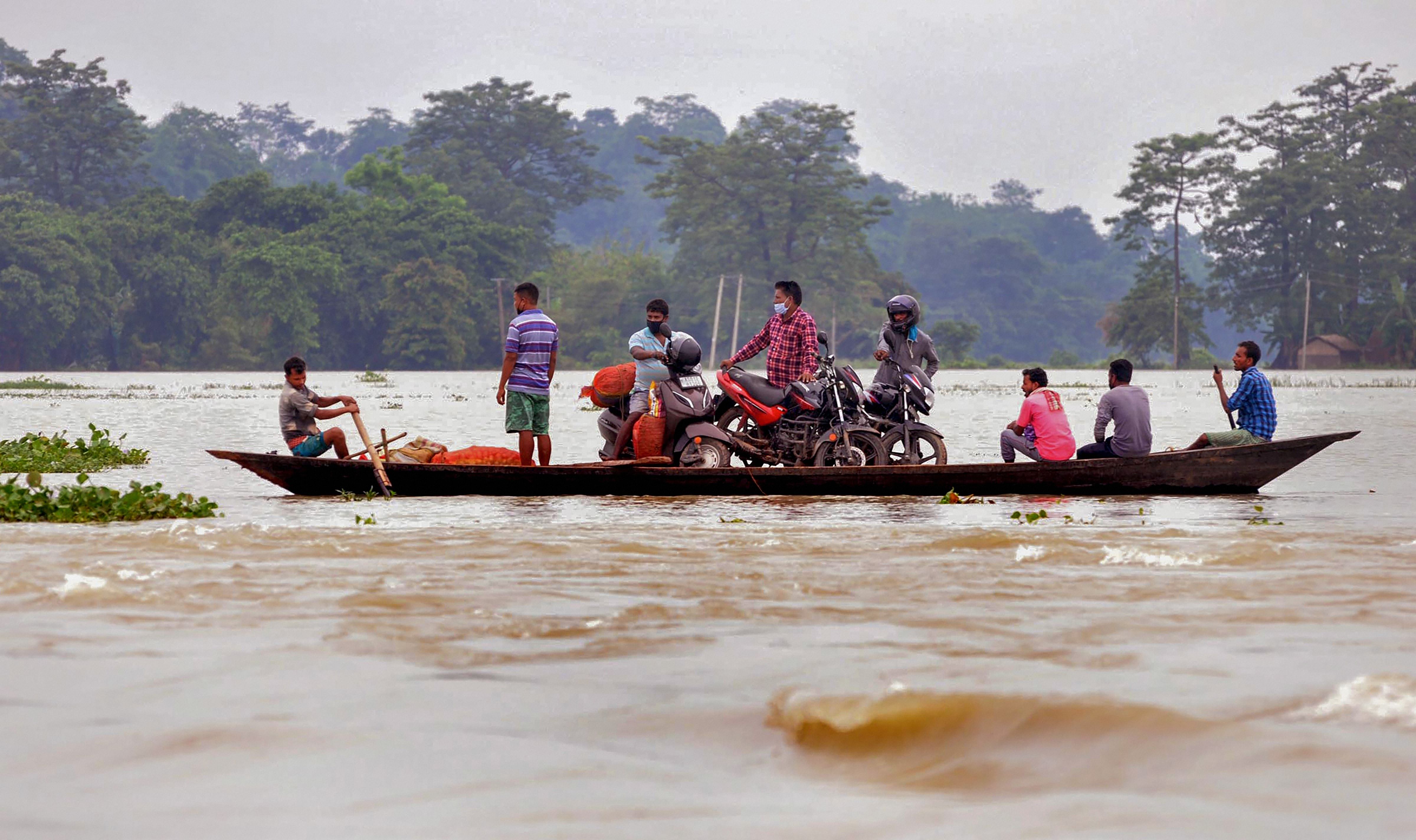  Villagers cross a flooded area on a boat, following heavy monsoon rain. Credits: PTI Photo