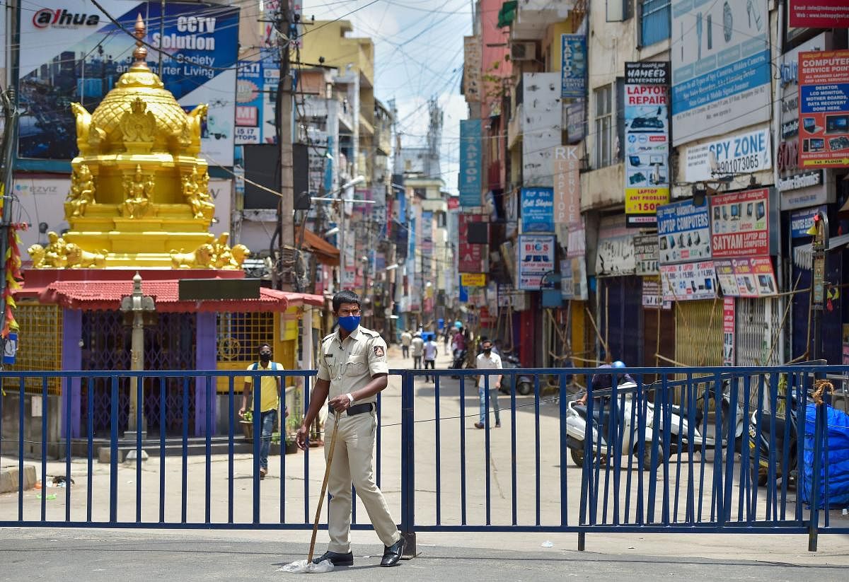  A policeman guards at Sadar Patrappa road locality as Karnataka government announced the area under lockdown after detection of several clusters of coronavirus infections, in Bengaluru, Thursday, June 25, 2020. (PTI)