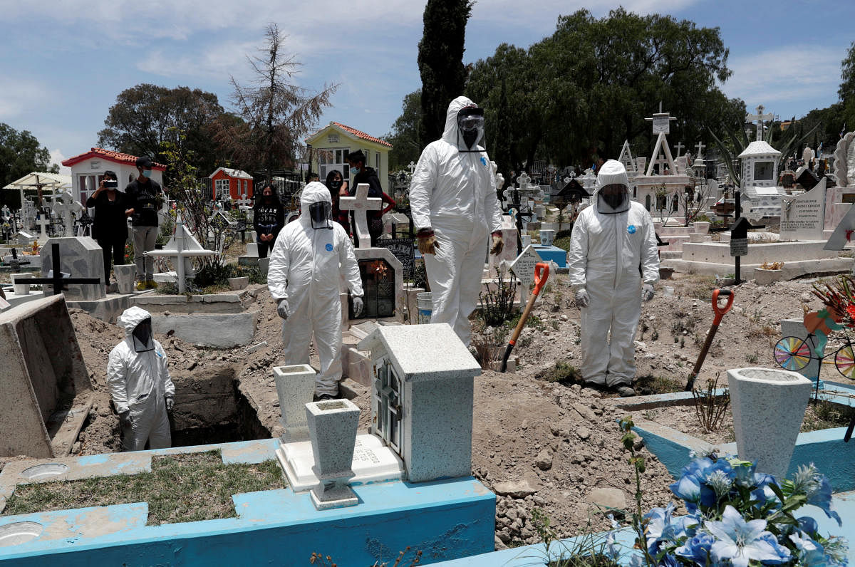 Cemetery workers wearing protective suits complete the burial of a man, who died of the coronavirus disease (COVID-19), at San Efren Municipal Cemetery, as the coronavirus disease (COVID-19) outbreak continues, in Ecatepec de Morelos, on the outskirts of Mexico City, Mexico June 19, 2020. Credit/Reuters Photo