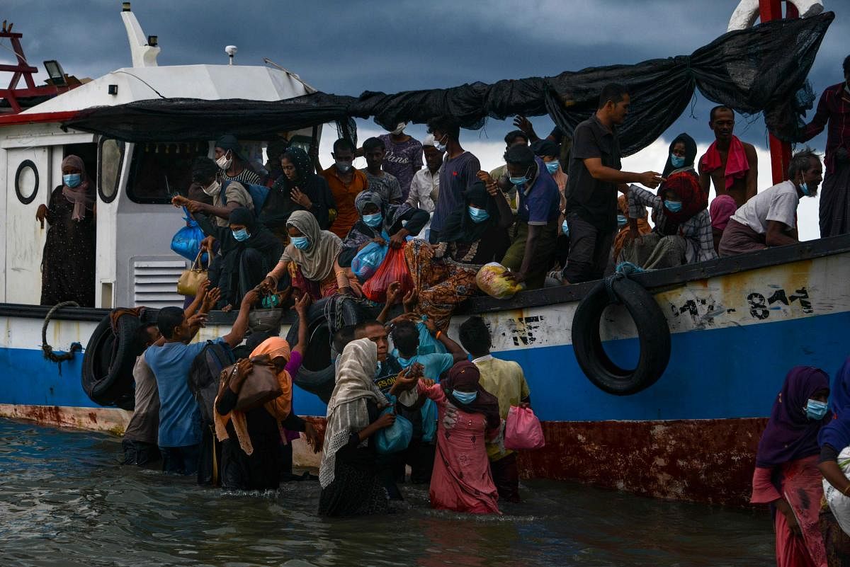 Acehnesse fishermen help evacuate Rohingya people from Myanmar from a boat onto the shorelines of Lancok village, in Indonesia's North Aceh Regency on June 25, 2020. Credit/PTI Photo