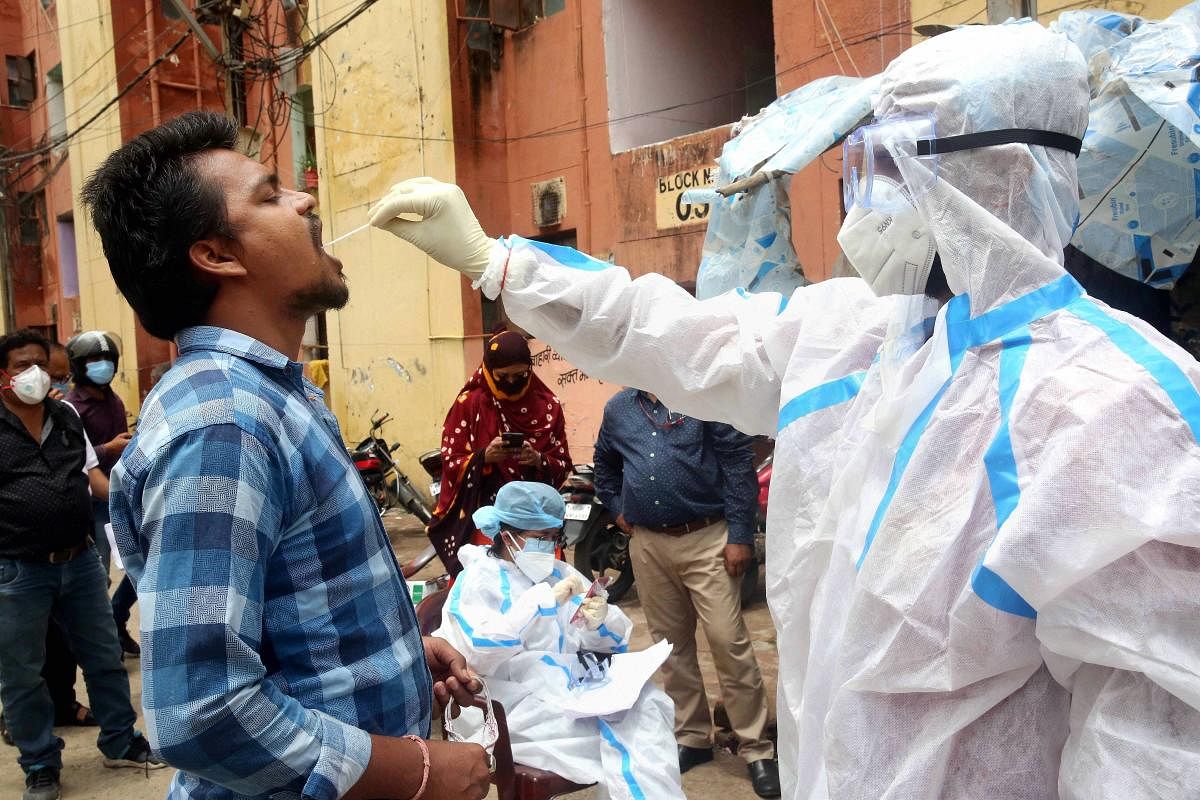  A medic collects swab samples from a man as part of a statewide door-to-door 'Kill Corona' campaign to curb the spread of coronavirus, in Bhopal, Saturday, June 27, 2020. Credit/PTI Photo