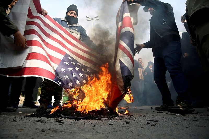 Demonstrators burn the US and British flags during a protest. Credits: Reuters Photo