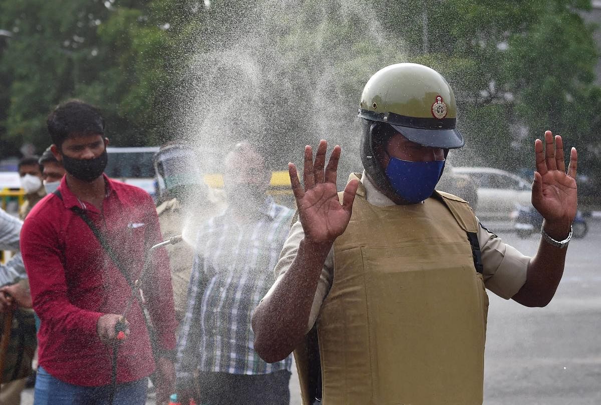 Bengaluru: A police officer being sanitized after the route march as the state government announced strict lockdown due to surge in COVID-19 cases at City market area, in Bengaluru, Saturday, June 27, 2020. (PTI Photo/Shailendra Bhojak)(PTI27-06-2020_0002