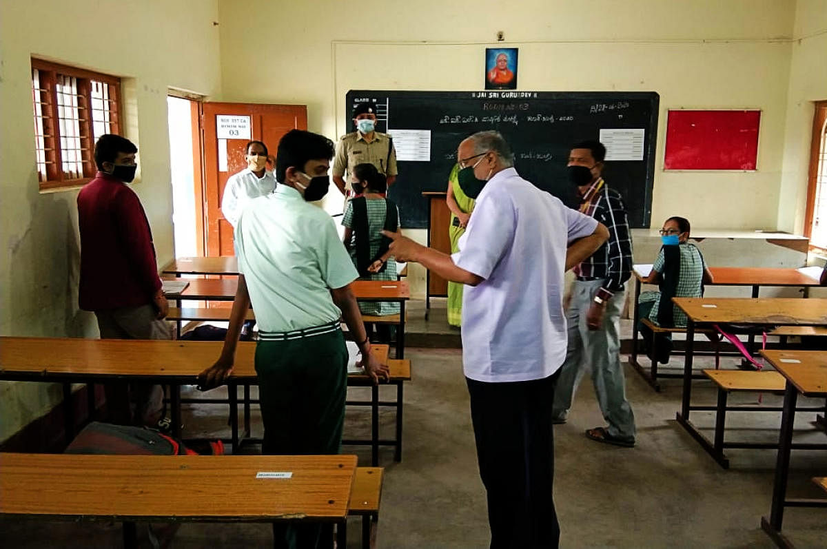 Primary and Secondary Education Minister S Suresh Kumar interacts with a SSLC student at BGS High School on the outskirts of Chikkaballapur on Monday. DH Photo