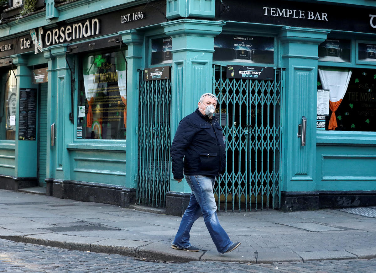 A man wearing a protective face mask passes The Norseman pub, as bars across Ireland are to close voluntarily to curb the spread of coronavirus in Dublin. Reuters/file