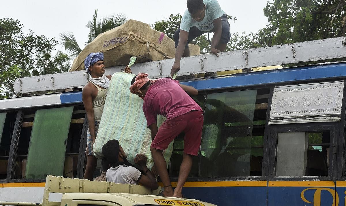 Labourers load goods on a long-route bus during the fifth phase of Covid-19 lockdown, in Kolkata. PTI/file