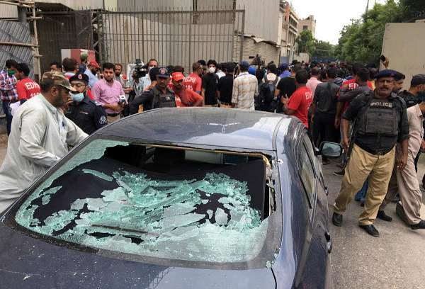 A plainclothes police officer (L) surveys the site of an attack at the Pakistan Stocks Exchange entrance in Karachi June 29, 2020. Credit: Reuters