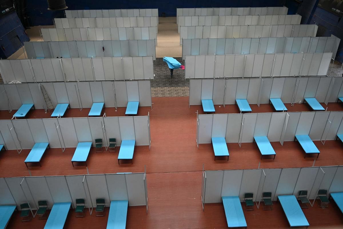 A worker carries foam mattresses as the Commonwealth Games (CWG) Village Sports Complex is converted into a temporary COVID-19 coronavirus care centre, in New Delhi (AFP Photo)