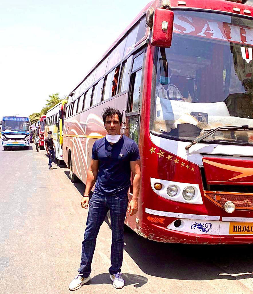 Sonu Sood with a fleet of buses hired for migrants. A grateful woman worker has named her just-born son after him.