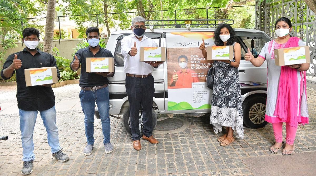 Ramesh Kumar Shah (centre), founder of RK Group, and team distributing free masks at Padarayanapura.