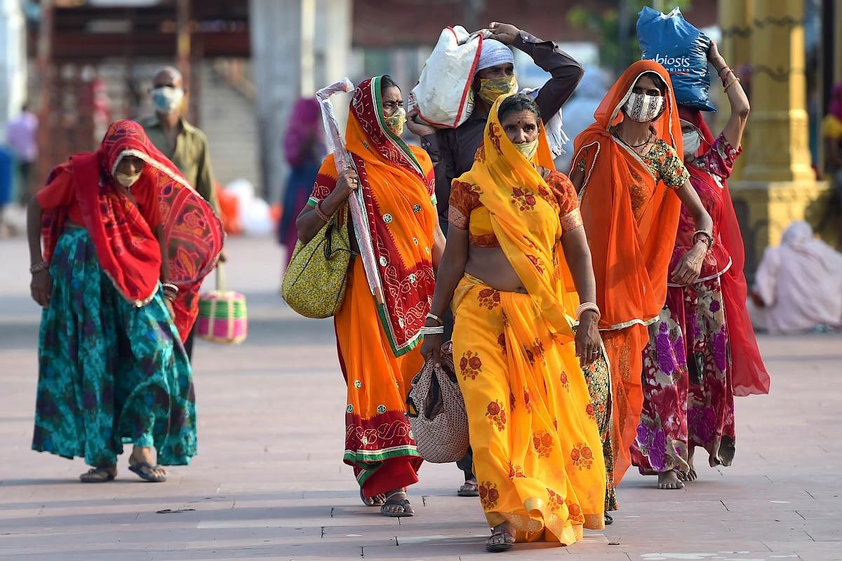 Hindu devotees wearing facemasks arrive at Har Ki Pauri ghat on the banks of the river Ganges, after the government eased a nationwide lockdown imposed as a preventive measure against the Covid-19 coronavirus at Haridwar in Uttarakhand state. Credit/AFP Photo