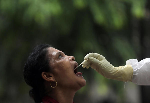 A health-worker wearing personal protective equipment (PPE) collects a sample using a swab from a woman during a check-up campaign for the coronavirus disease (COVID-19), at a residential society in Mumbai. Credit: Reuters